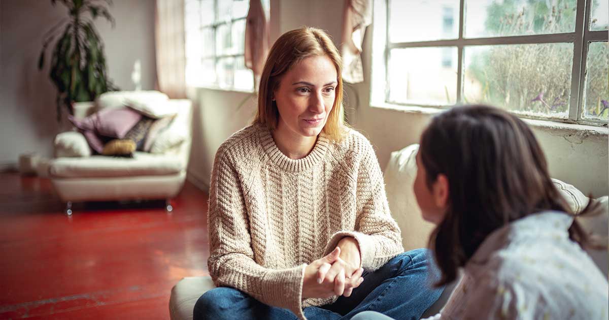 female friends on couch listening to each other